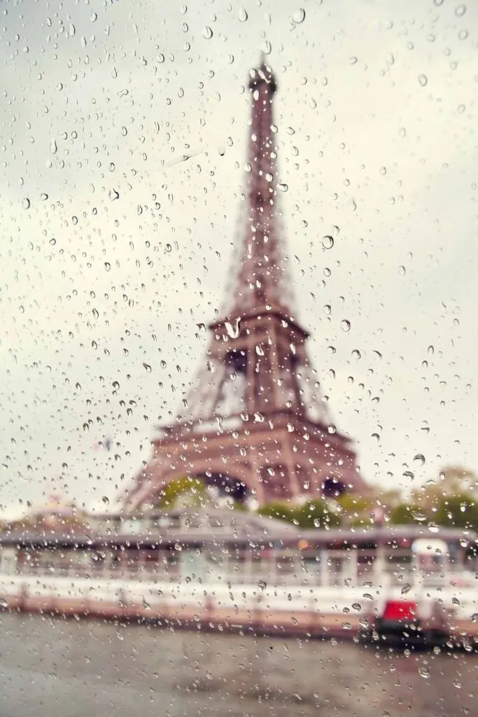 Eiffel Tower seen through glass on a rainy day