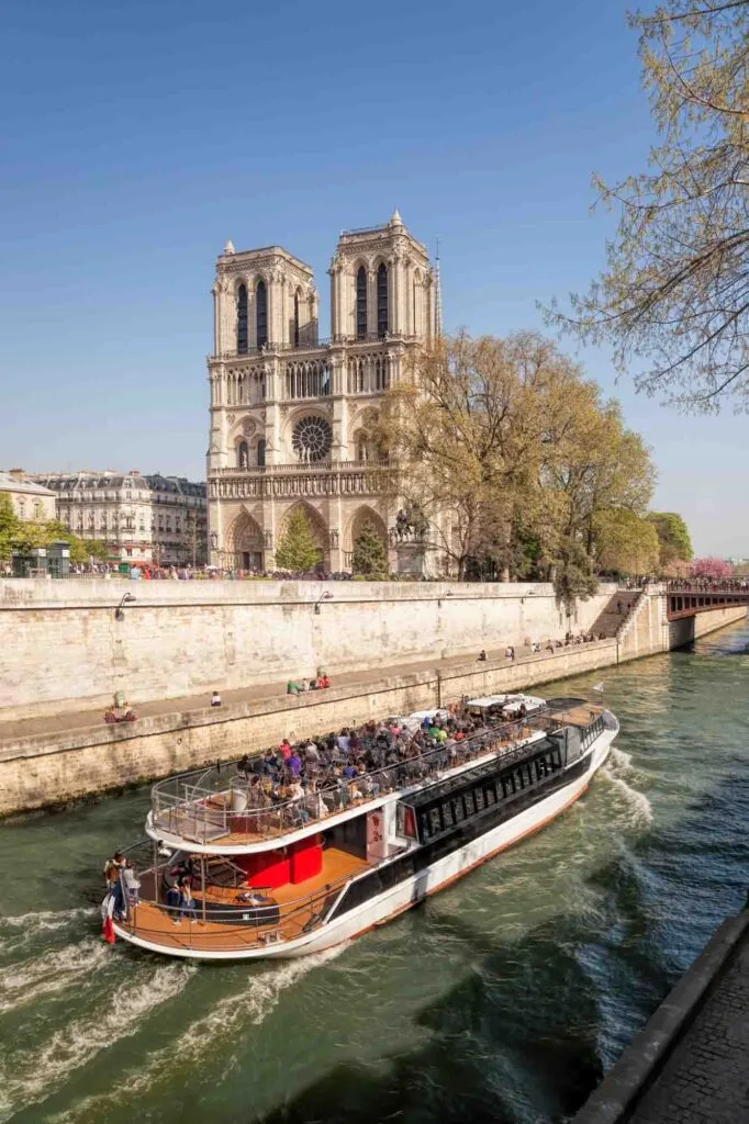 Boat cruising the Seine River in Paris and Notre Dame Cathedral in the background