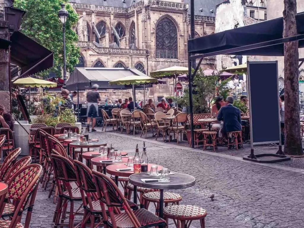 Cozy street with tables of cafe in Les Marais, Paris