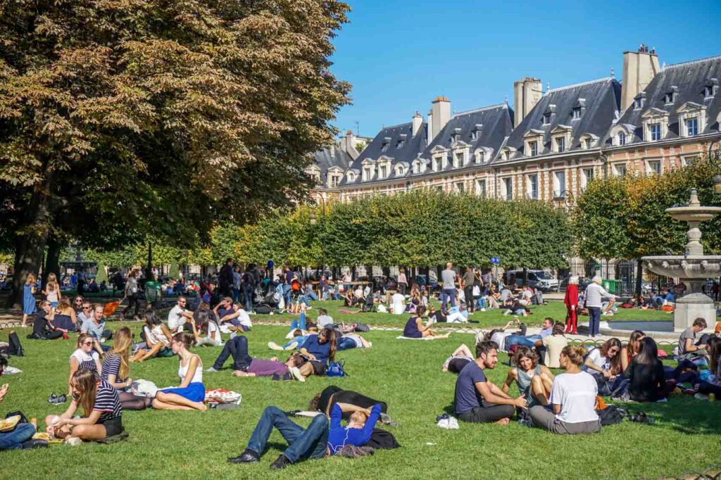 People sunbathing and picnicking at Place des Vosges