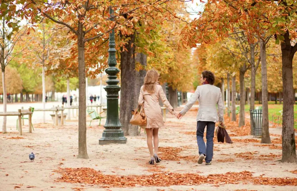 Couple walking underneath fall foliage in Paris