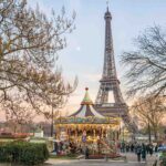 Eiffel Tower and vintage carousel in Paris at sunset during winter