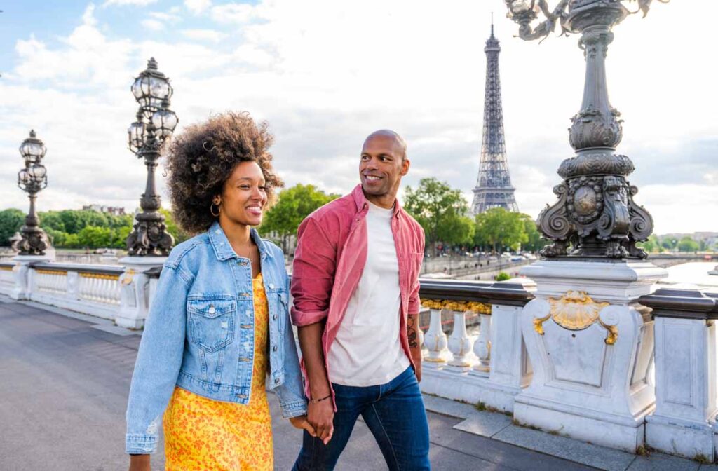 Happy couple in love walking over Pont Alexandre III bridge with Eiffel Tower in the background