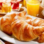 Delicious continental breakfast with croissants, assorted preserves, orange juice, and coffee