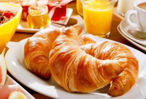 Delicious continental breakfast with croissants, assorted preserves, orange juice, and coffee