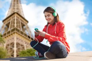 Woman listening to French songs near the Eiffel Tower in Paris