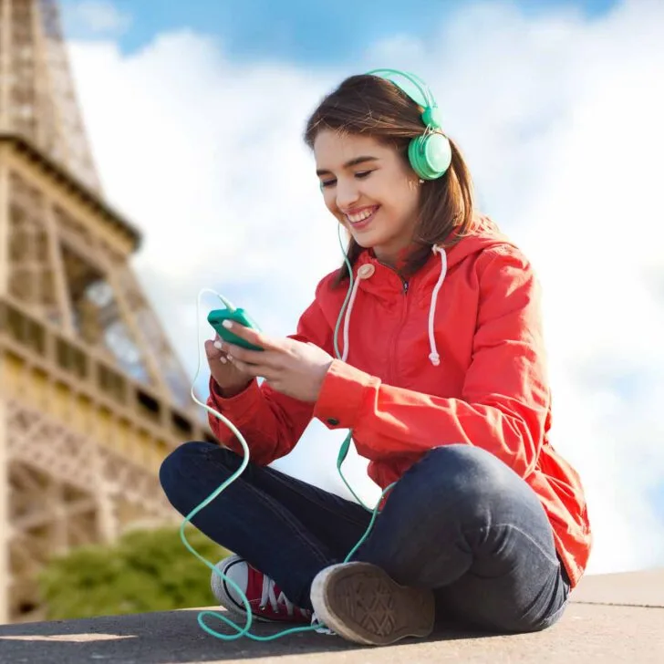 Woman listening to French songs near the Eiffel Tower in Paris
